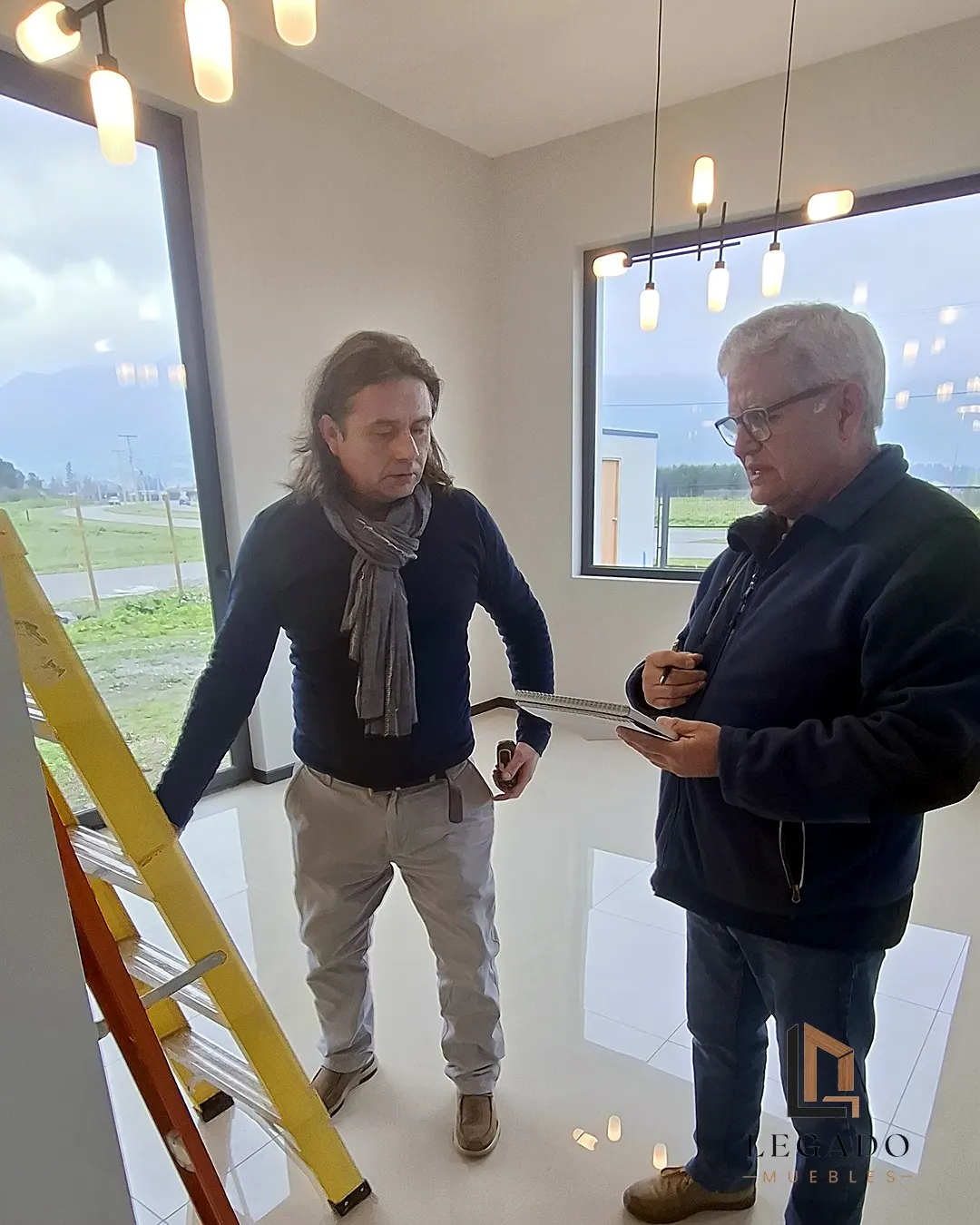 Dos integrantes del equipo revisando medidas en una casa en obra